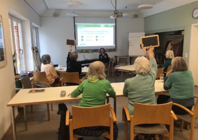 Gruppe von Seniorinnen aus einem Service Center spielt das Zukunftsquiz von Omas for Future München