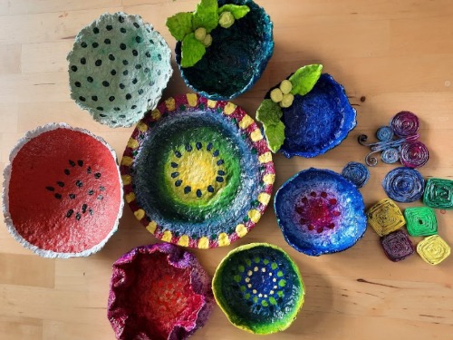 Sechs handgefertigte Grußkarten aus Wellpappe sind auf einem Tisch angeordnet. Jede Karte ist mit verschiedenen Streifen gemusterten Klebebands und einem ausgeschnittenen Herz verziert. Der Hintergrund scheint eine weiche Filzmatte zu sein.