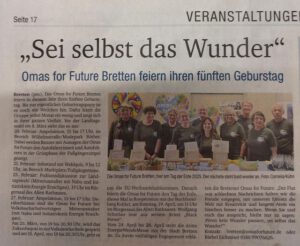 Ein Zeitungsartikel mit der Überschrift Sei selbst das Wunder. Unten ist ein Foto einer Gruppe von Menschen in passenden T-Shirts zu sehen, die zusammenstehen und lächeln, um den fünften Jahrestag von Omas for Future Bretten zu feiern.